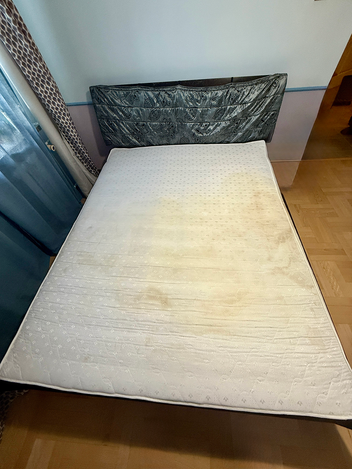 Brudny biały materac przed usługą prania tapicerki.